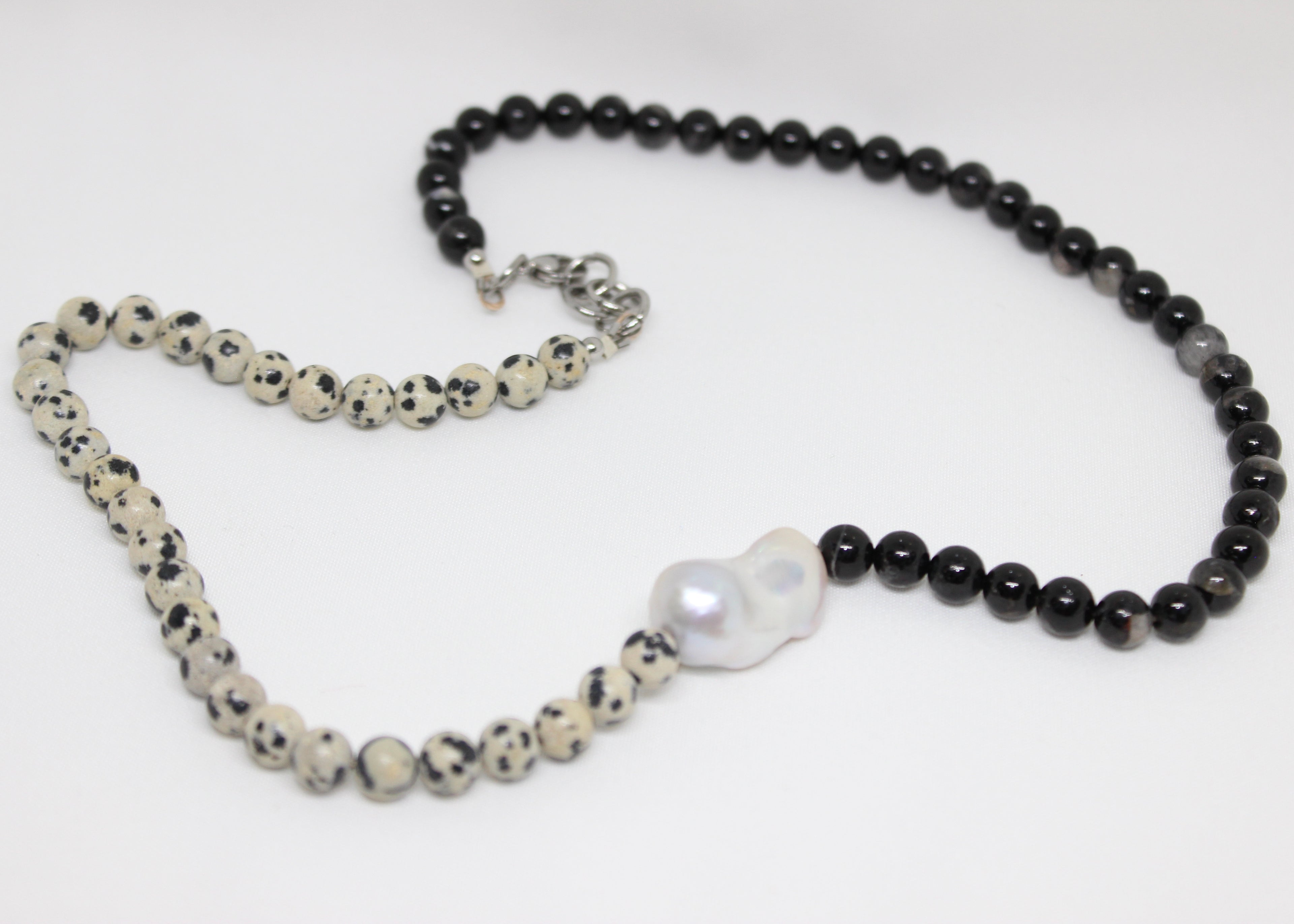 Beaded necklace with black tourmaline, dalmatian jasper, and freshwater pearl centerpiece.