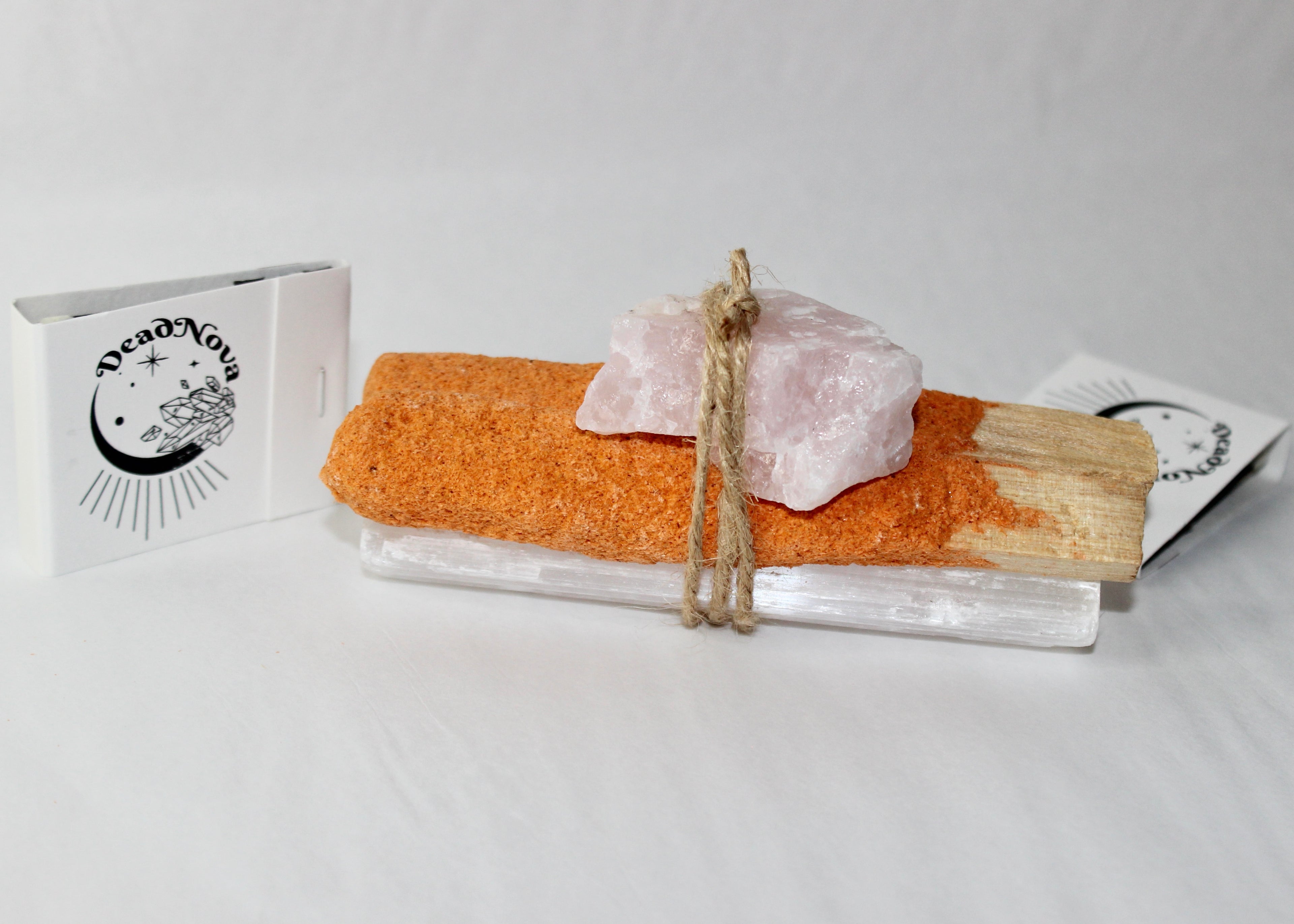Pumpkin spice palo santo bundle with rose quartz and selenite tied together in twine beside a mini pumpkin, smoke rising  autumn cleansing ritual aesthetic by DeadNova.