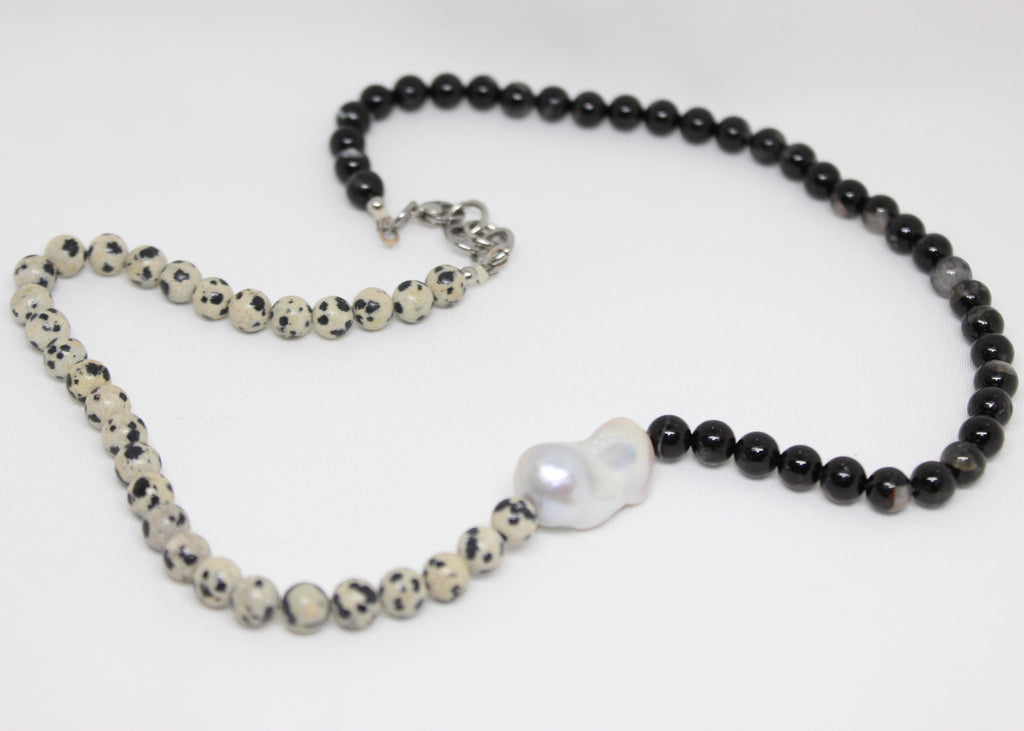 Beaded necklace with black tourmaline, dalmatian jasper, and freshwater pearl centerpiece.
