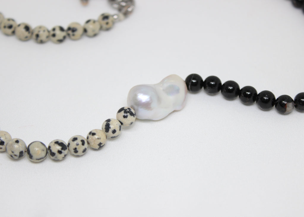 Beaded necklace with black tourmaline, dalmatian jasper, and freshwater pearl centerpiece.