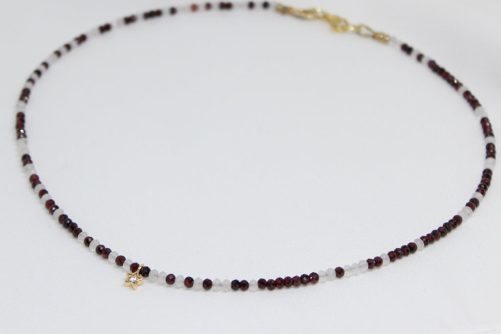 Necklace with garnet and rose quartz beads and a gold star 