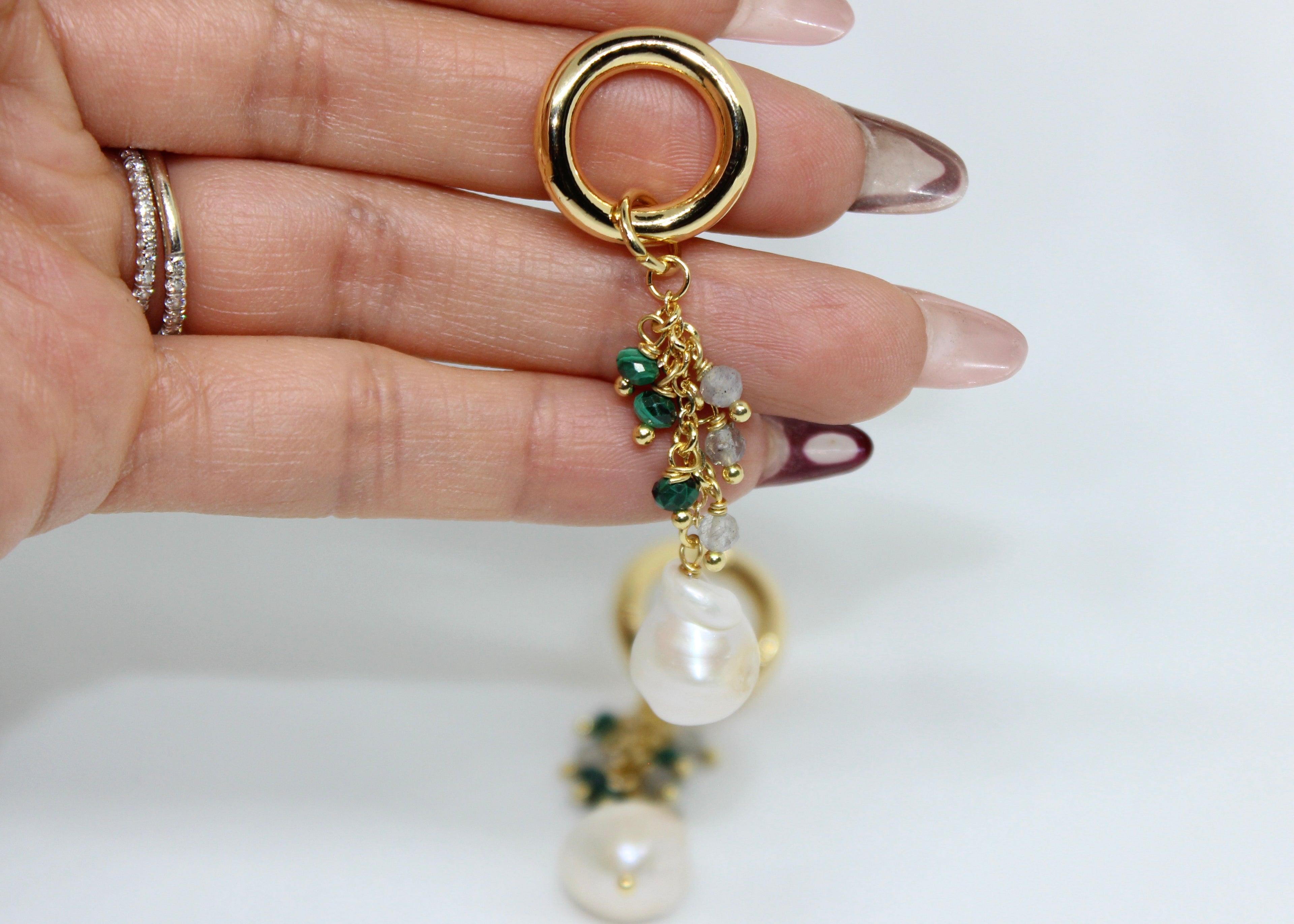 Elegant dangly earrings with clusters of malachite, labradorite beads, and freshwater pearls on gold hoops.