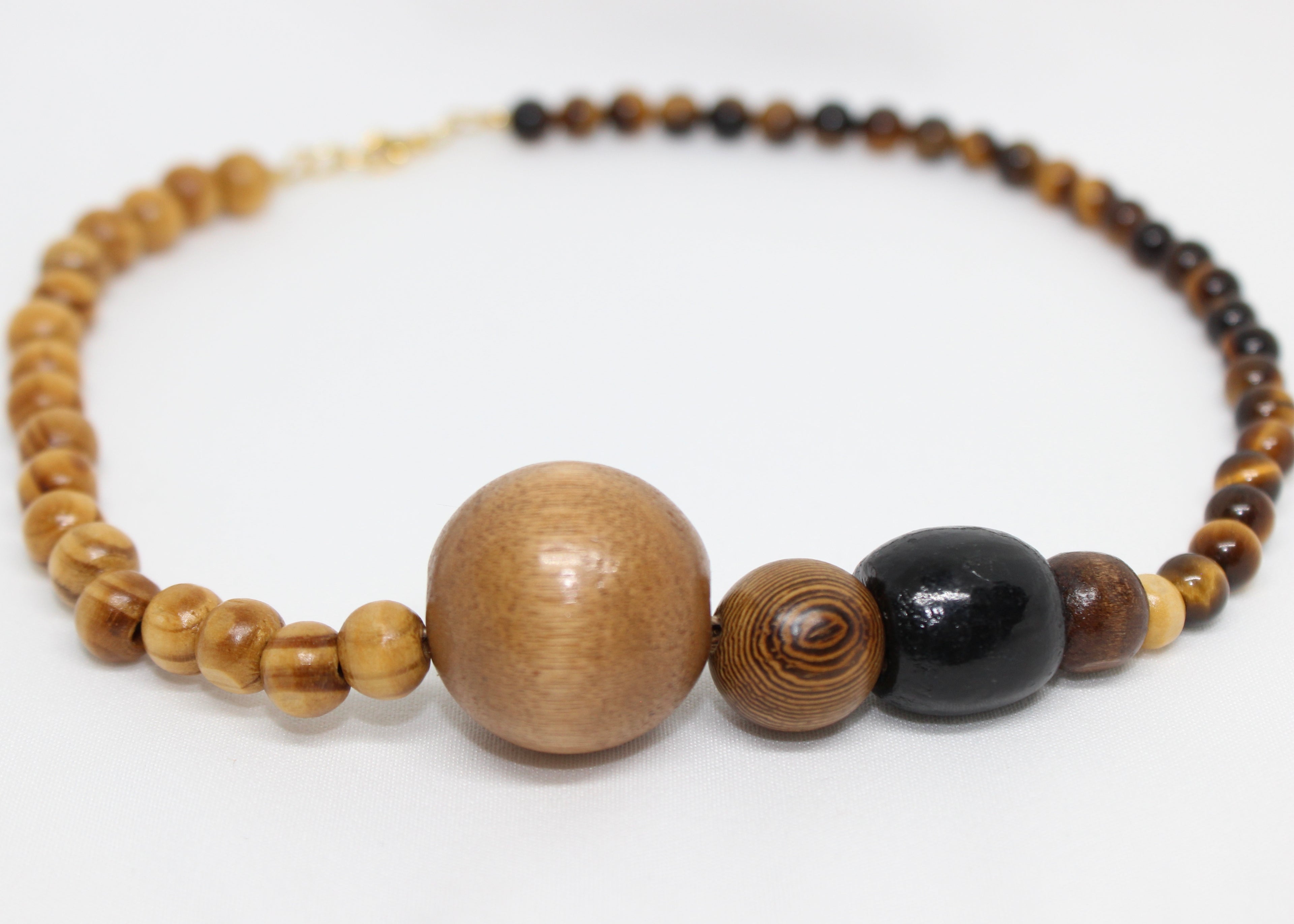 Beaded necklace with wood, gold accents, and asymmetrical tiger’s eye beads for grounding energy.