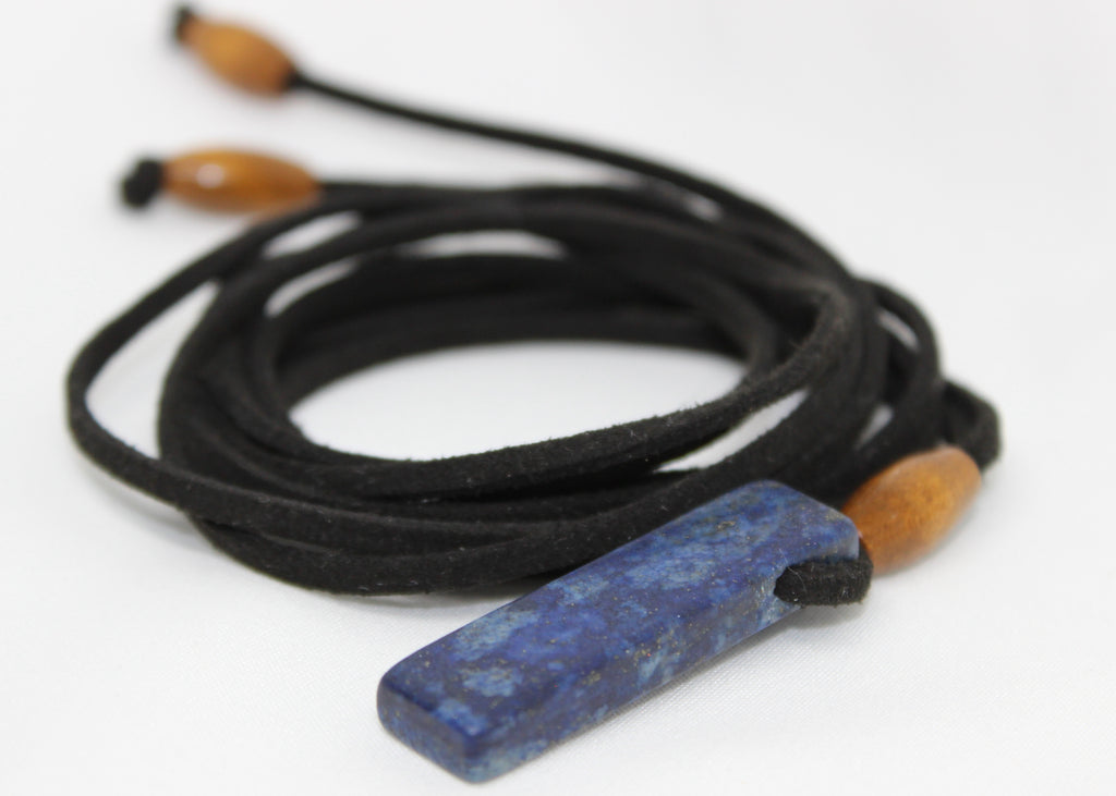 Adjustable necklace made with wood beads and a lapis lazuli pendant on suede cord, worn as necklace or choker.