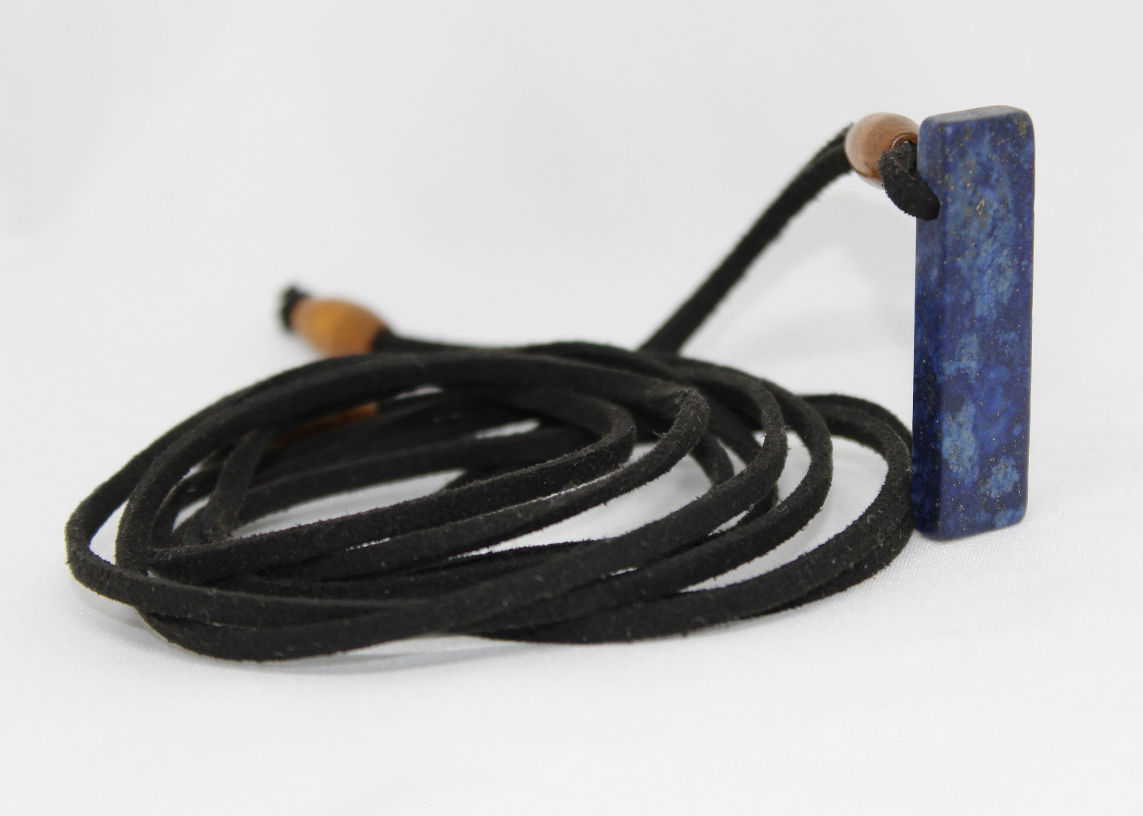 Adjustable necklace made with wood beads and a lapis lazuli pendant on suede cord, worn as necklace or choker.