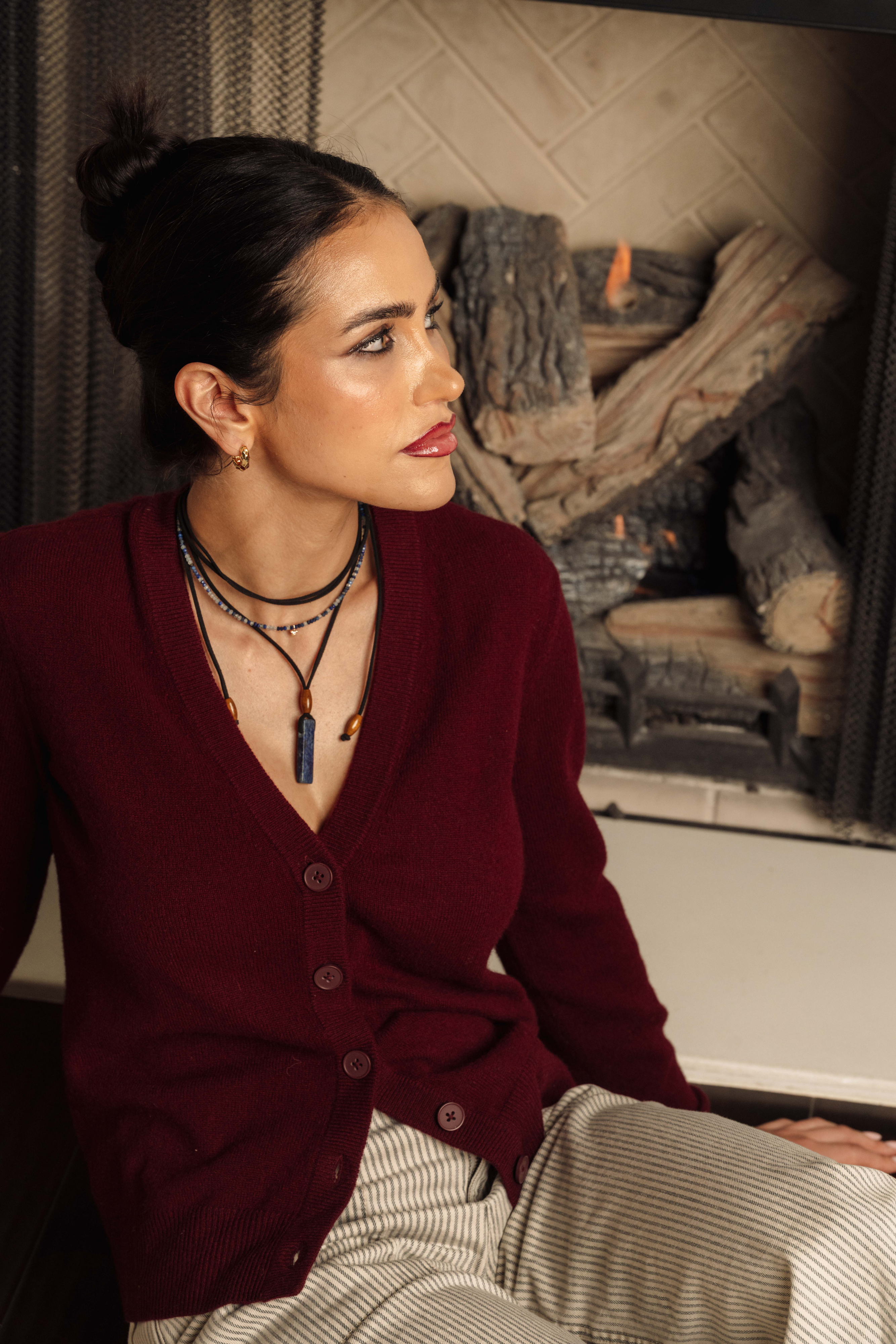 Adjustable necklace made with wood beads and a lapis lazuli pendant on suede cord, worn as necklace or choker.