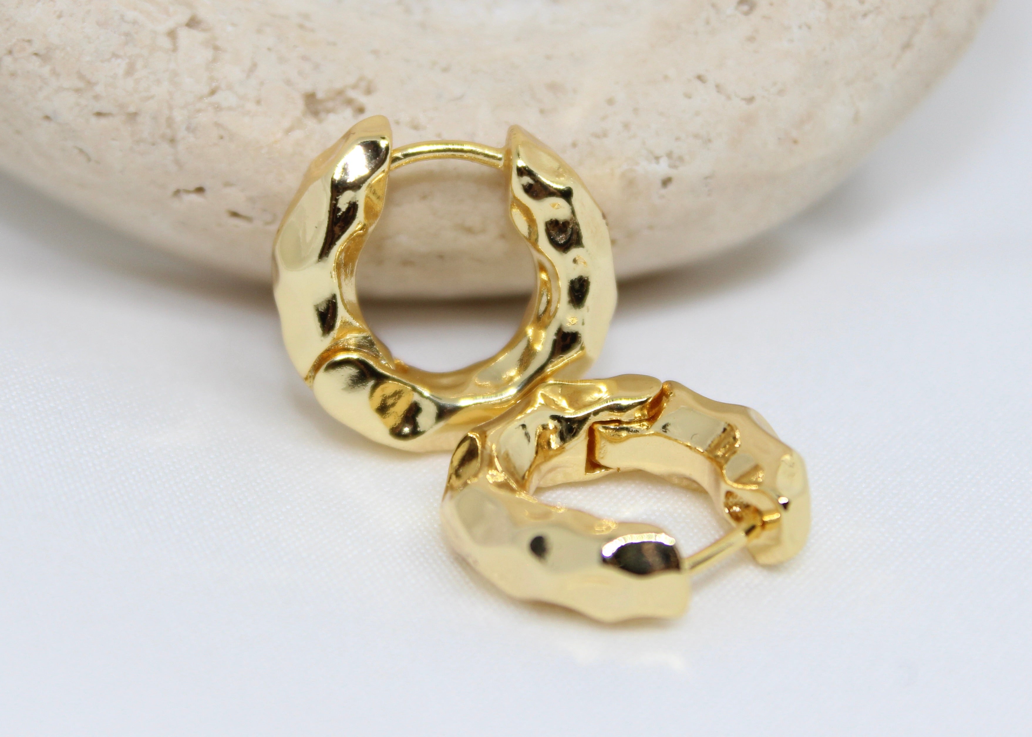 Chunky hammered gold hoop earrings in a sculptural round design, bold non-tarnish hoops for modern style.