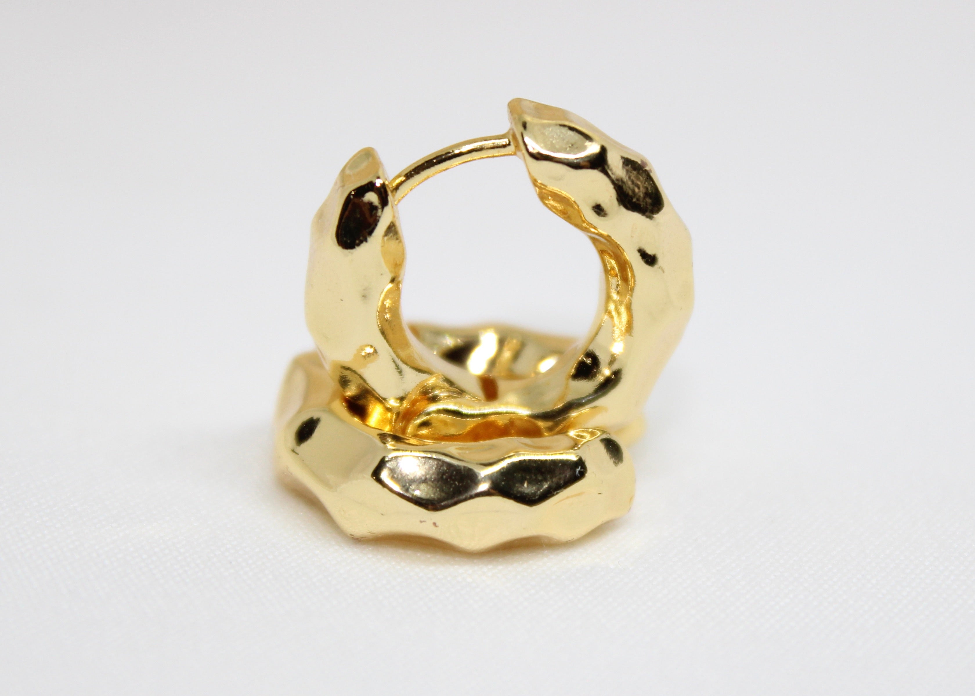 Chunky hammered gold hoop earrings in a sculptural round design, bold non-tarnish hoops for modern style.